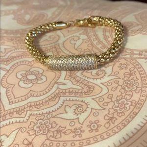 Goldtone bracelet with barrel of clear pave stones